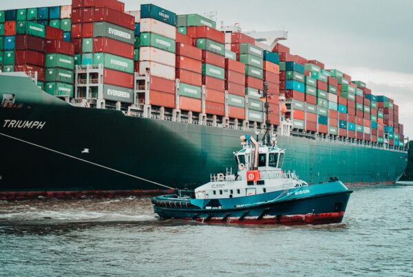 a tug boat pulling a large container ship
